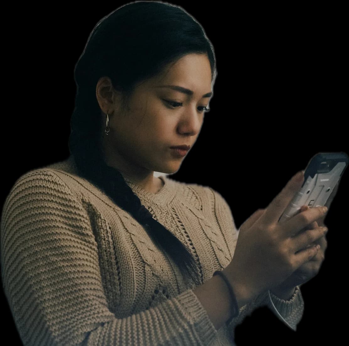 A woman in a knit jumper reading her phone